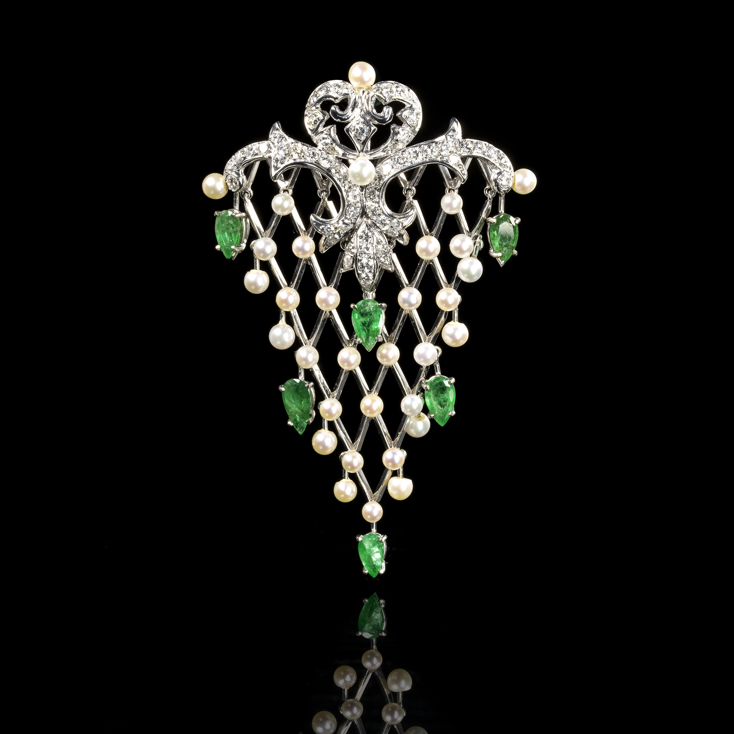 A gold emerald diamonds and pearl fishnet pendant.